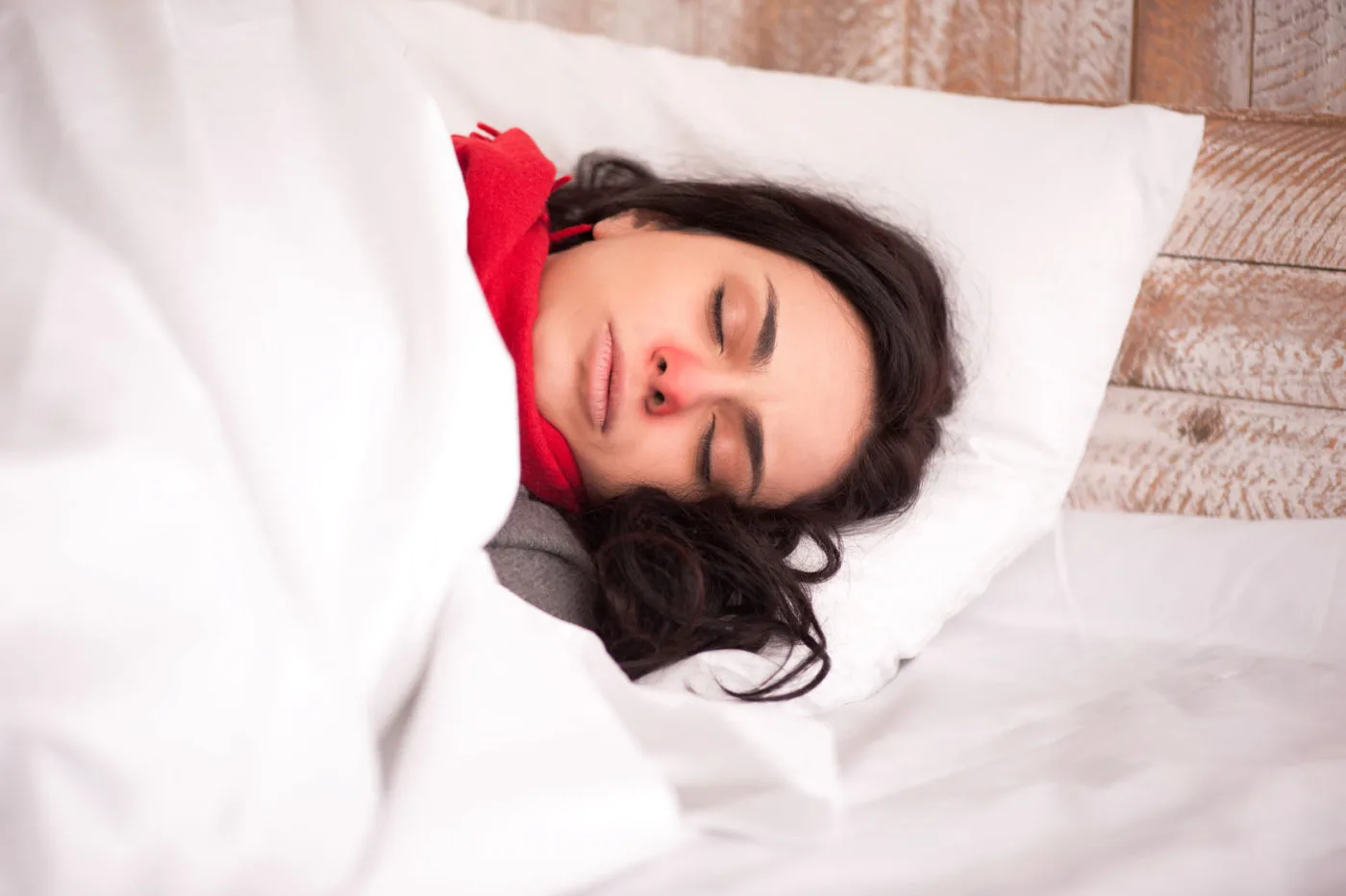35557479 - feeling unwell. closeup image of young sick woman sleeping in bed with sore throat in scarf